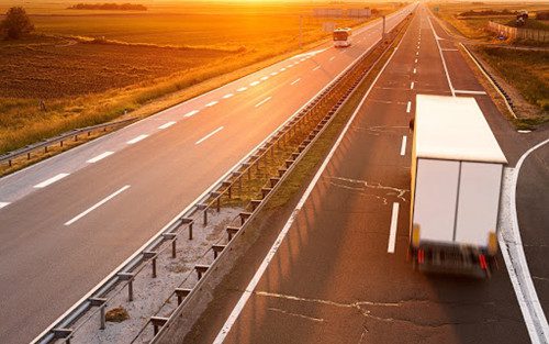 Truck and bus on highway in motion blur at sunset